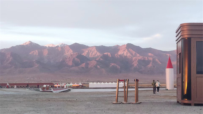 中途歇腳處，遠(yuǎn)處為戈壁和高山，夕陽(yáng)映射下，延綿不絕的高山呈火紅的獨(dú)特風(fēng)貌，甚是絕美！